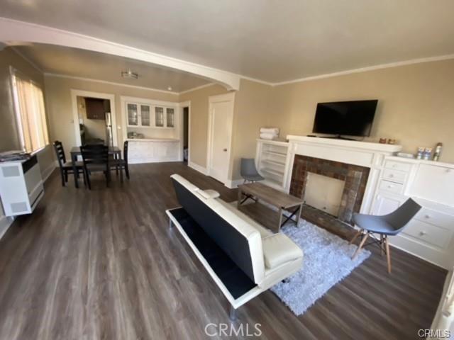 3030 W 12th Pl, Los Angeles, CA 90006 - living room with dark wood-type flooring, a fireplace, baseboards, and ornamental molding