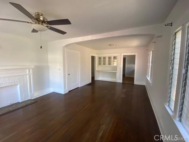 3030 W 12th Pl, Los Angeles, CA 90006 - unfurnished living room with baseboards, a ceiling fan, wood finished floors, and a fireplace with raised hearth