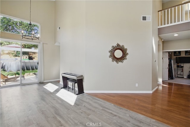 45924 Via Ln, Colorada, Temecula, CA 92592 - unfurnished living room featuring a high ceiling, a chandelier, wood finished floors, and baseboards