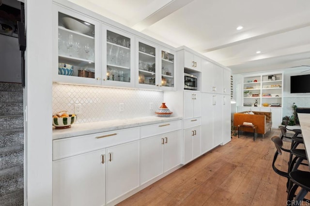 5171 College Gardens Ct, San Diego, CA 92115 - kitchen with beam ceiling, light wood-style flooring, backsplash, light countertops, and white cabinetry