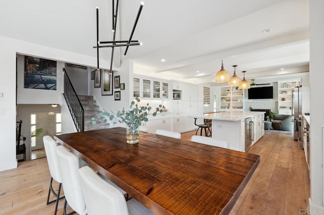5171 College Gardens Ct, San Diego, CA 92115 - dining space with stairway, light wood-type flooring, a chandelier, a fireplace, and wine cooler