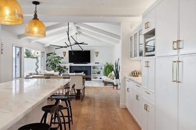 5171 College Gardens Ct, San Diego, CA 92115 - kitchen with light wood-style floors, a kitchen bar, light stone countertops, and open floor plan