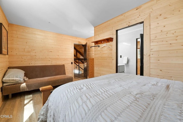 bedroom featuring wood finished floors and wood walls