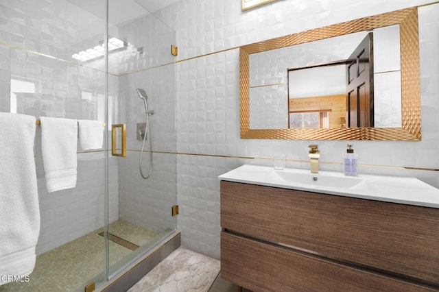 bathroom with a stall shower, vanity, and tile walls