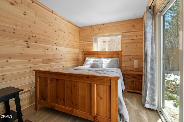 unfurnished bedroom featuring wooden walls and light wood finished floors