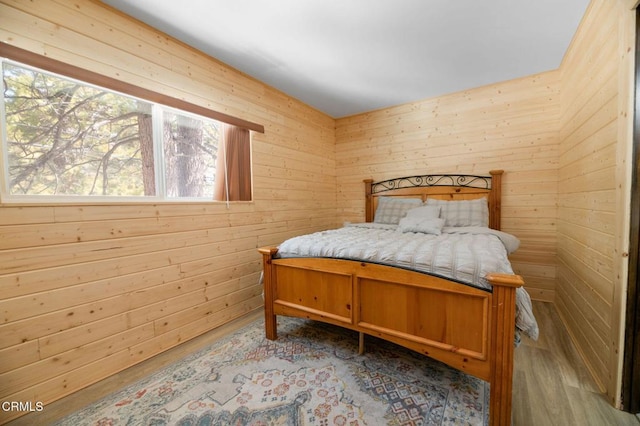 bedroom featuring wood walls