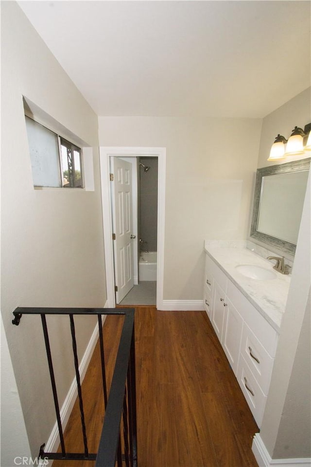 bathroom with baseboards, wood finished floors, and vanity