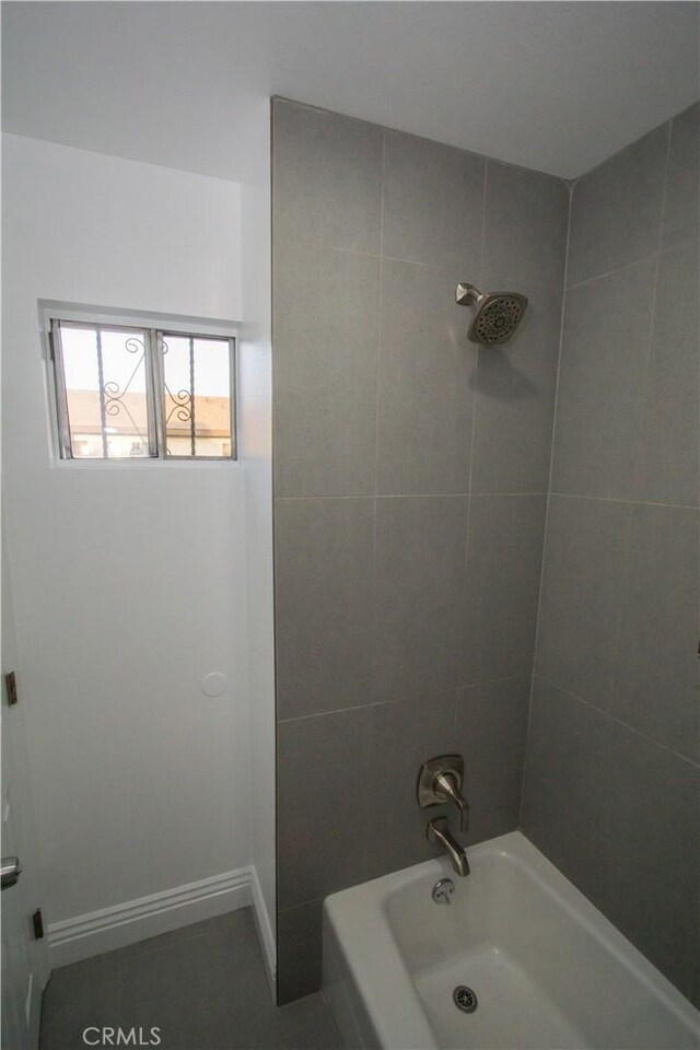 bathroom with baseboards and shower / bathing tub combination