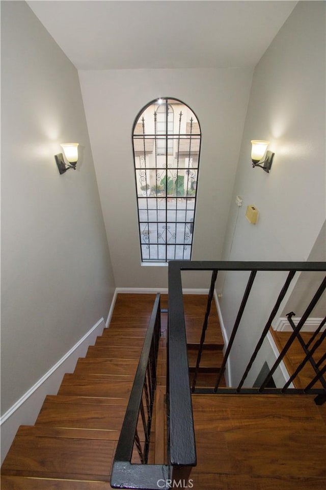 staircase with baseboards and wood finished floors