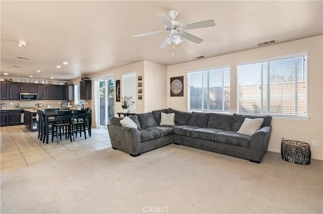 3070 Sand Pine Trl, Hemet, CA 92545 - living area with light tile patterned flooring, light colored carpet, visible vents, and ceiling fan