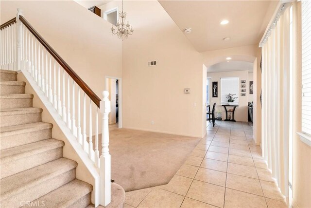 3070 Sand Pine Trl, Hemet, CA 92545 - staircase featuring tile patterned flooring, visible vents, carpet, arched walkways, and a notable chandelier