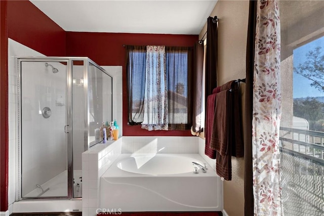 bathroom with a bath and a stall shower
