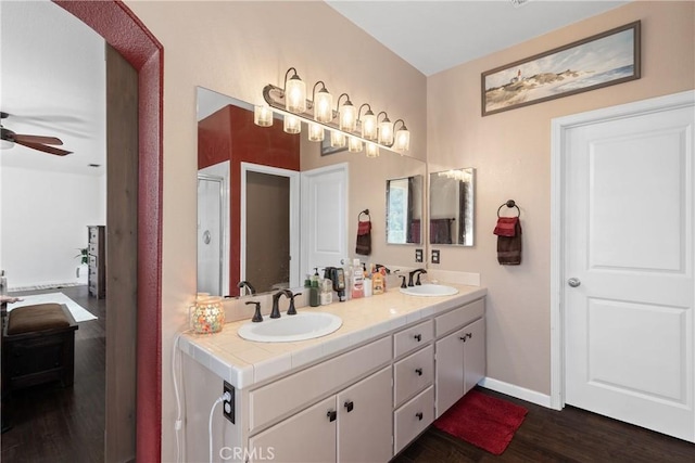 bathroom with ceiling fan, wood finished floors, baseboards, and a sink