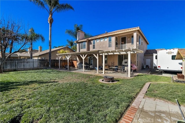 rear view of property featuring a lawn, a pergola, a fenced backyard, a balcony, and a patio area
