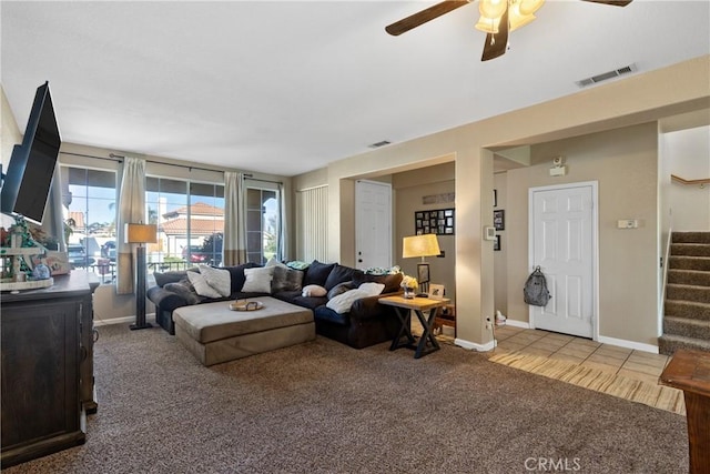 living room featuring visible vents, baseboards, stairs, carpet floors, and a ceiling fan