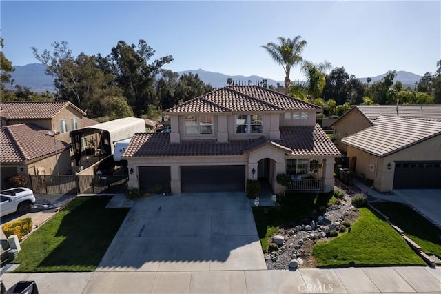 mediterranean / spanish-style home with a mountain view, an attached garage, and a tile roof