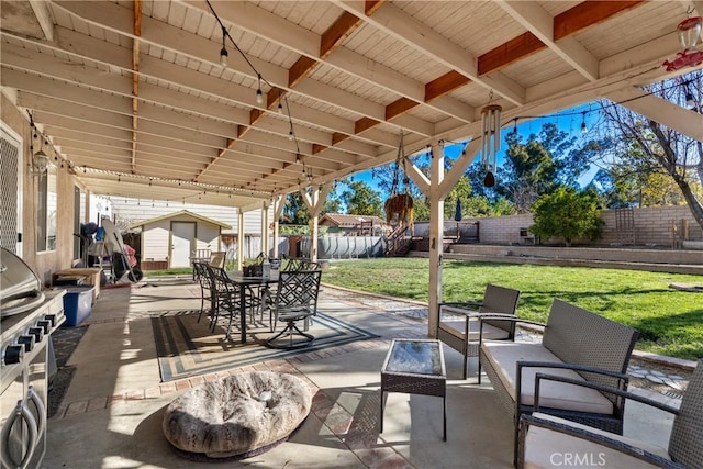 view of patio with outdoor dining space, an outbuilding, a fenced backyard, a storage unit, and an outdoor hangout area