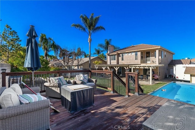 wooden deck featuring a fenced in pool and an outdoor hangout area