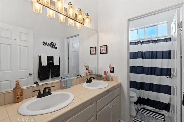 full bathroom featuring a sink, a shower with curtain, toilet, and double vanity