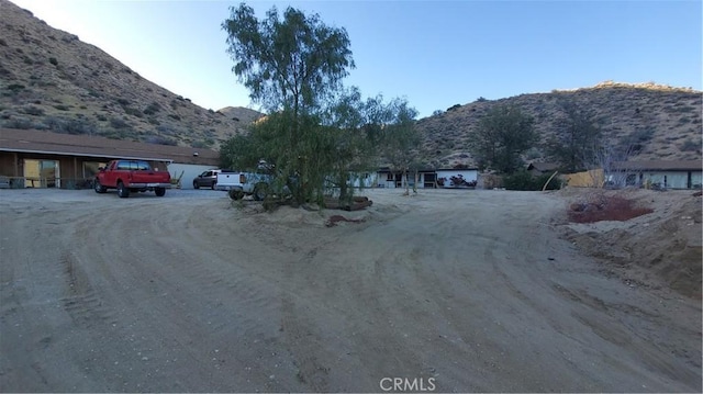 view of road with a mountain view and dirt driveway