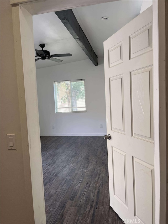 spare room with beamed ceiling, baseboards, ceiling fan, and dark wood-style flooring
