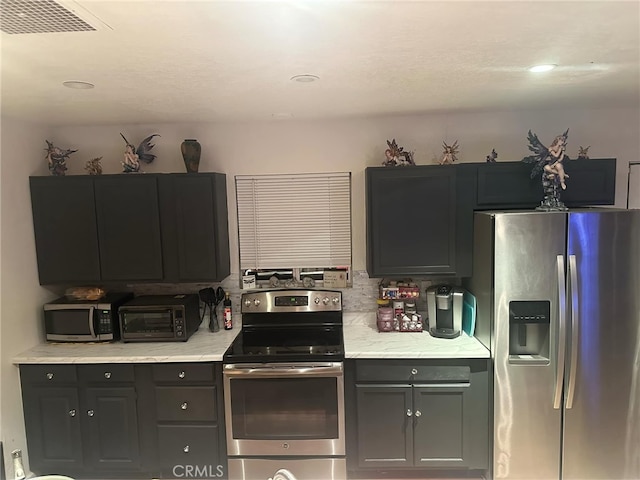 kitchen with visible vents, backsplash, a toaster, gray cabinets, and stainless steel appliances