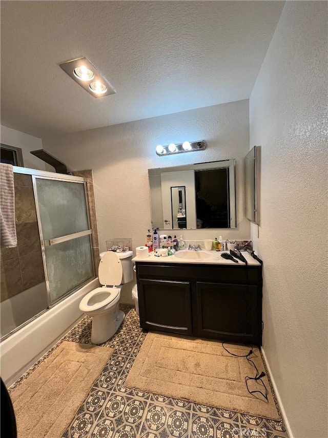 full bathroom with toilet, a textured ceiling, bath / shower combo with glass door, vanity, and a textured wall