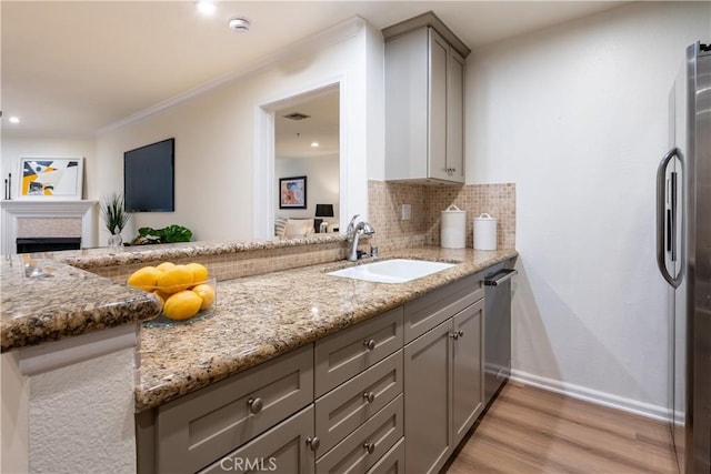 7320 Hawthorn Ave Unit 111, Los Angeles, CA 90046 - kitchen featuring gray cabinets, appliances with stainless steel finishes, a sink, light wood-style flooring, and light stone countertops