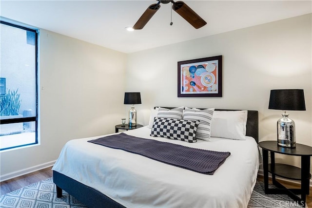 7320 Hawthorn Ave Unit 111, Los Angeles, CA 90046 - bedroom with multiple windows, wood finished floors, baseboards, and a ceiling fan