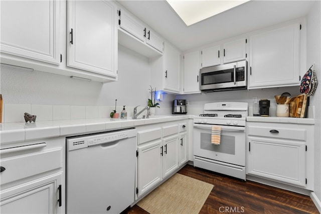 kitchen featuring white cabinetry, white appliances, tile counters, and dark wood finished floors