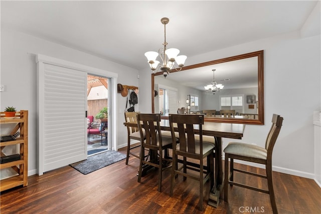 dining space with a notable chandelier, baseboards, and wood finished floors