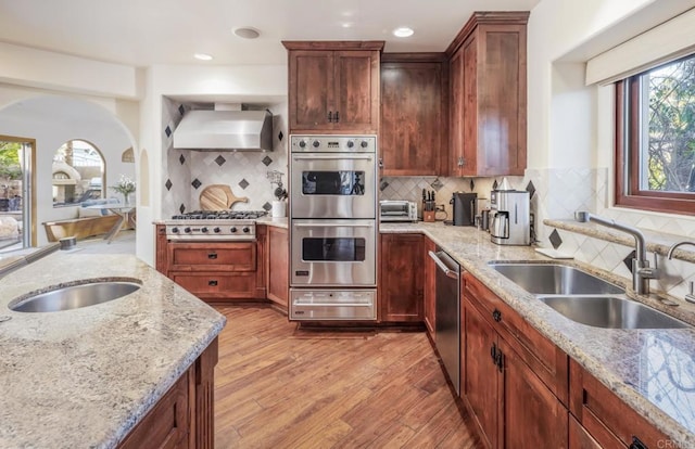 112 La Veta Ave, Encinitas, CA 92024 - kitchen featuring light stone countertops, appliances with stainless steel finishes, a sink, wall chimney exhaust hood, and a warming drawer