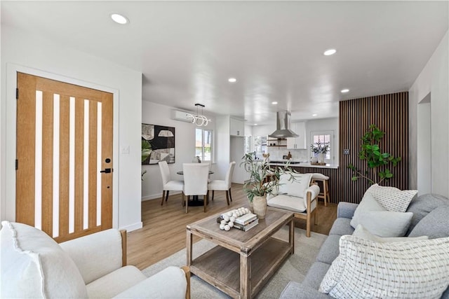 living room with baseboards, recessed lighting, and light wood-style floors