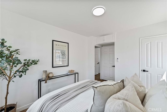 bedroom with baseboards and wood finished floors