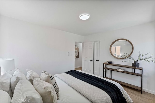 bedroom featuring light wood-type flooring and baseboards