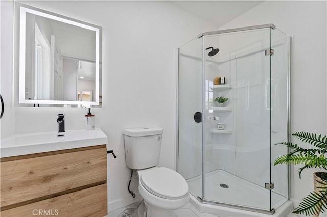 bathroom with a shower stall, vanity, baseboards, and toilet