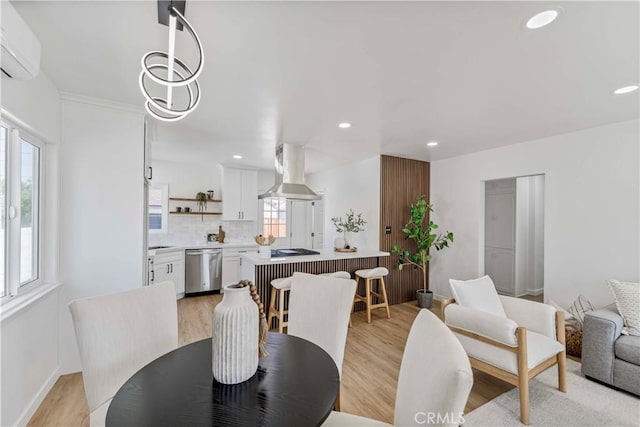 dining area with a wall mounted air conditioner, recessed lighting, and light wood-style floors