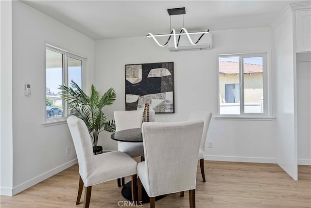 dining space with baseboards, light wood-type flooring, and a notable chandelier