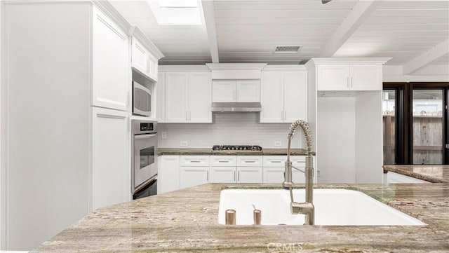 3317 Lees Ave, Long Beach, CA 90808 - kitchen featuring oven, a sink, beam ceiling, tasteful backsplash, and white cabinets