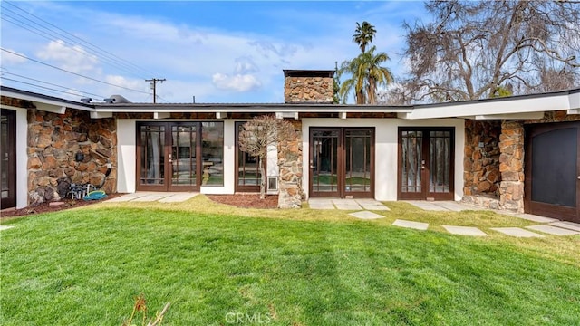 3317 Lees Ave, Long Beach, CA 90808 - back of house featuring stone siding, a chimney, and a lawn