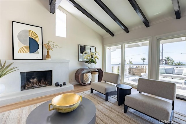 living area with plenty of natural light, beamed ceiling, and wood finished floors
