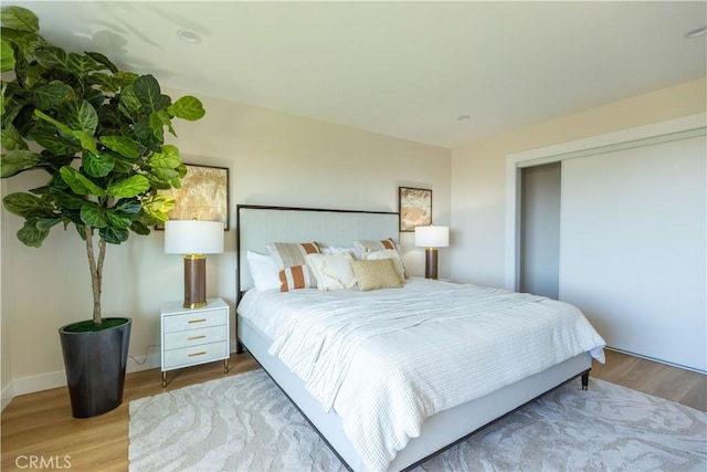 bedroom featuring baseboards and wood finished floors