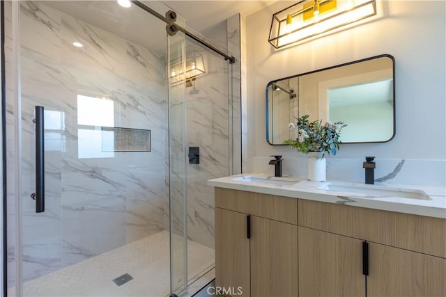 full bathroom featuring a marble finish shower, double vanity, and a sink