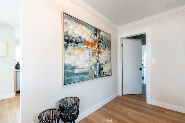 hall with baseboards, wood finished floors, and ornamental molding