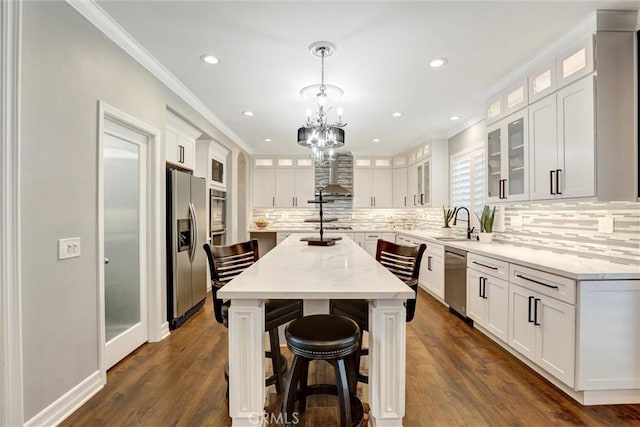 1610 Via Roma Cir, Corona, CA 92881 - kitchen featuring white cabinetry, a kitchen island, ornamental molding, and stainless steel appliances