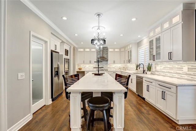 1610 Via Roma Cir, Corona, CA 92881 - kitchen with appliances with stainless steel finishes, a kitchen island, crown molding, white cabinets, and wall chimney exhaust hood