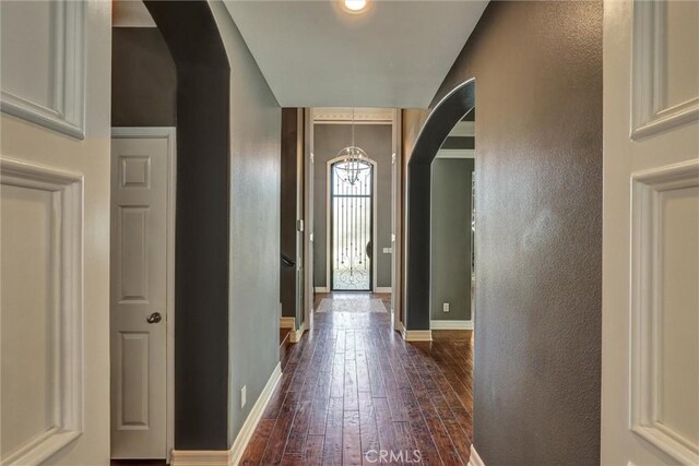 1610 Via Roma Cir, Corona, CA 92881 - entryway featuring baseboards, dark wood-style floors, arched walkways, and a notable chandelier
