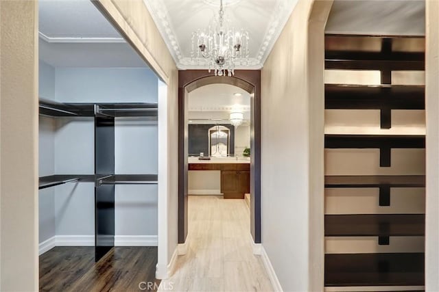1610 Via Roma Cir, Corona, CA 92881 - walk in closet featuring wood finished floors, a chandelier, and arched walkways