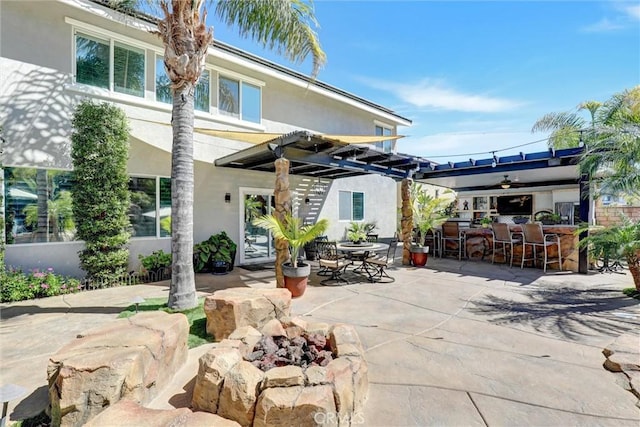1610 Via Roma Cir, Corona, CA 92881 - back of property with a fire pit, outdoor dry bar, a patio area, and stucco siding