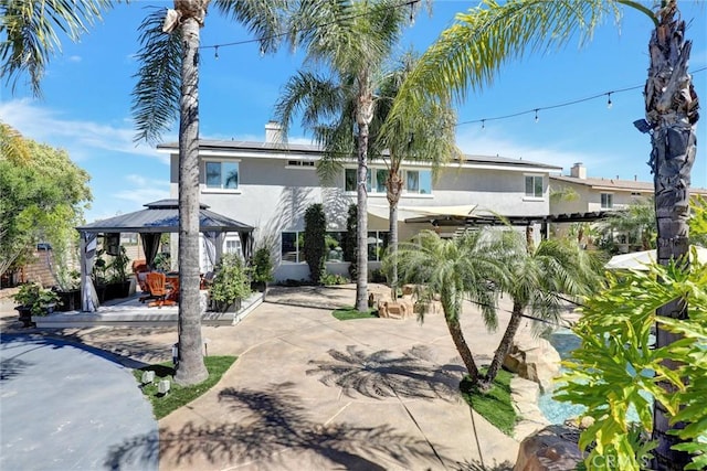 1610 Via Roma Cir, Corona, CA 92881 - view of front of home with roof mounted solar panels, a patio area, a gazebo, and stucco siding